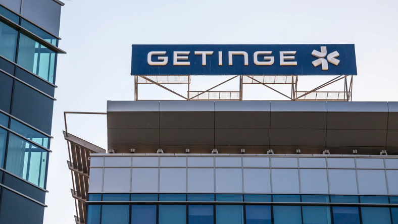 Getinge logo displayed on top of a modern hospital or office building