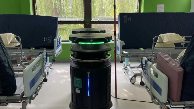 Automated hospital disinfection robot positioned between empty patient beds